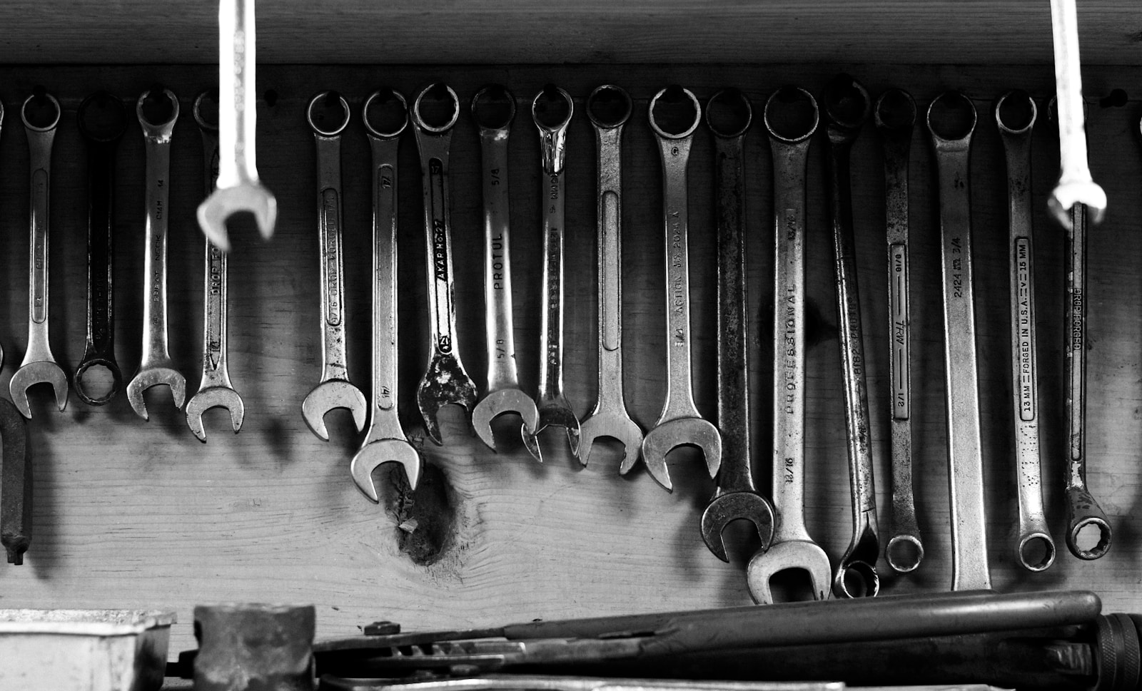 Wrenches hang on a wall in a workshop.